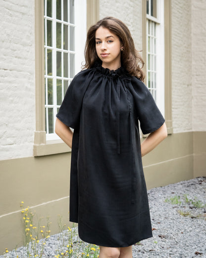Model draagt multiway zwart / antraciet zijden jurk No.6 van OAXO, hoge kraag gestyled.