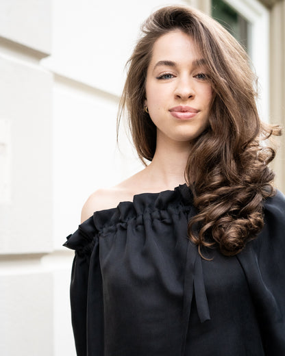 Model draagt multiway zwart / antraciet zijden jurk No.6 van OAXO, one-shoulder gestyled.